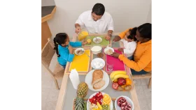 Cheerful Family Gathering Around Dinner Table Enjoying Meal Preparation Clipart